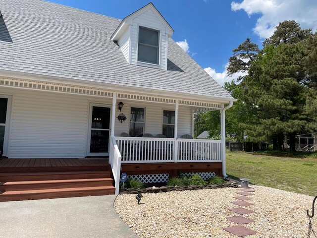 4097 Grand Bay Ct, Chincoteague, VA 23336 - property entrance with covered porch, a shingled roof, and a lawn