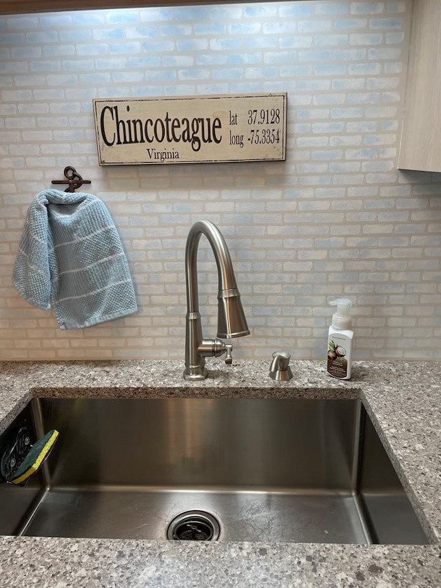 4097 Grand Bay Ct, Chincoteague, VA 23336 - kitchen view of a sink, brick wall, and light stone countertops