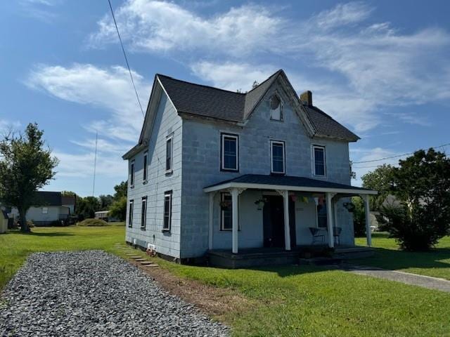 view of front of house with covered porch and a front lawn