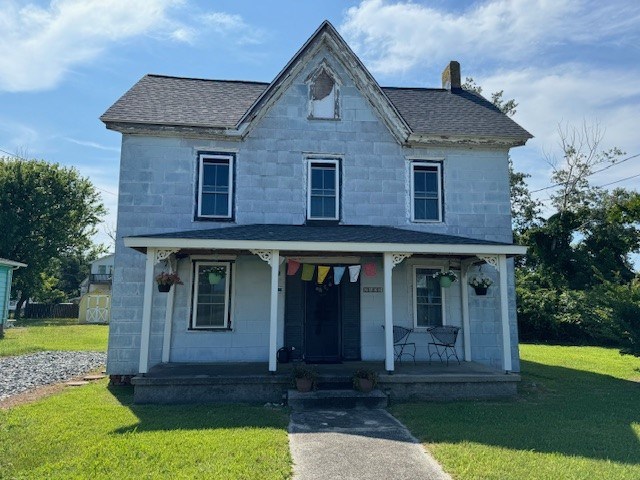 view of front of property with covered porch and a front lawn