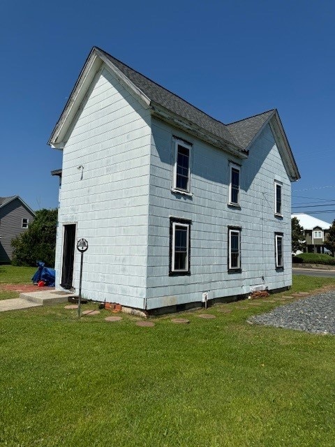 view of side of home with a yard