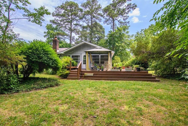 back of house with a lawn and a wooden deck