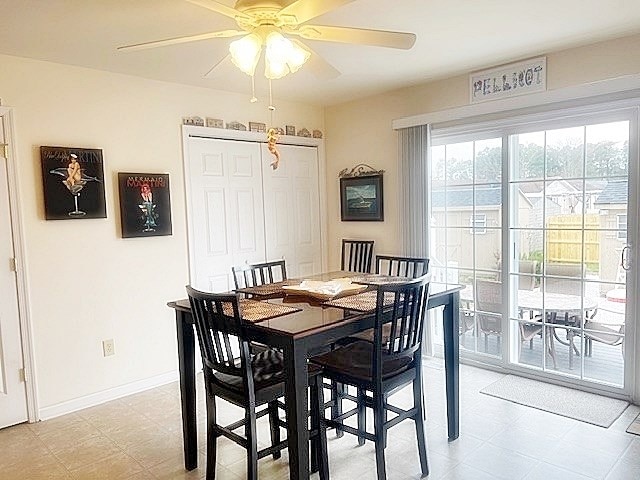 dining area featuring light floors, a ceiling fan, and baseboards