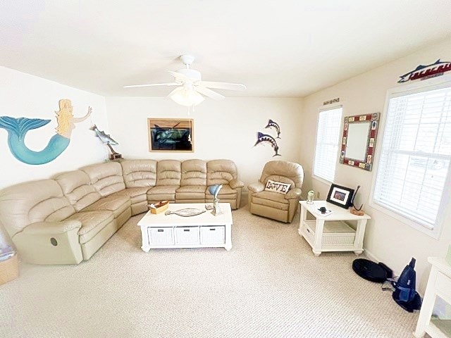 living area with a ceiling fan and light colored carpet