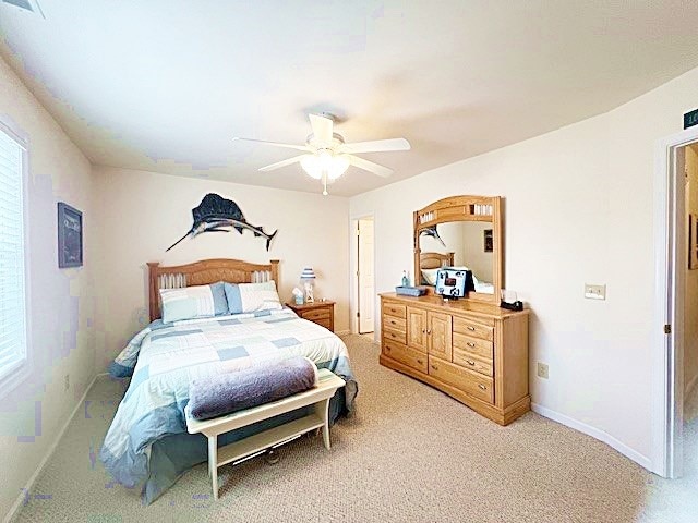 bedroom featuring ceiling fan, visible vents, baseboards, and carpet flooring