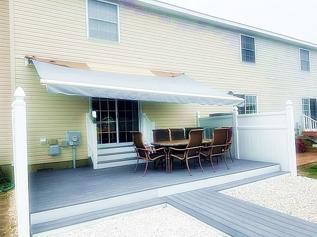 back of house featuring fence, a deck, and outdoor dining space