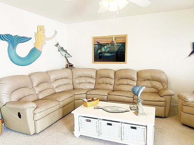 living room with a ceiling fan and light colored carpet