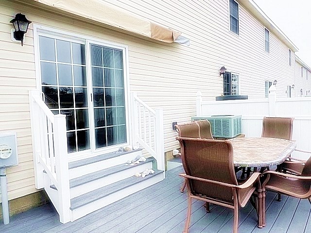 wooden deck with entry steps, central AC unit, and outdoor dining area