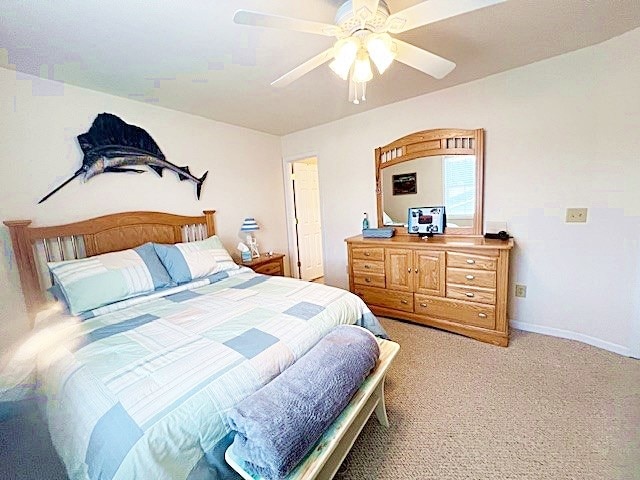 carpeted bedroom with a ceiling fan and baseboards