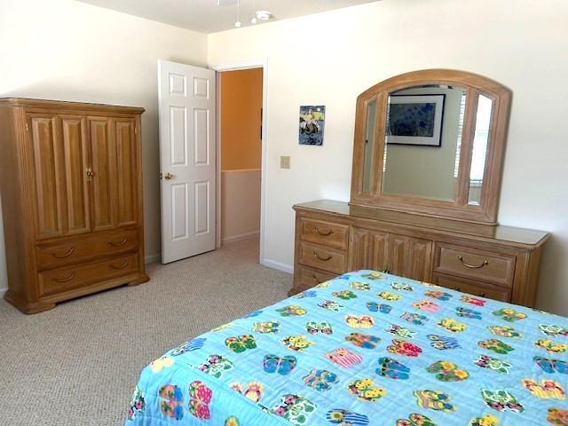 bedroom featuring baseboards and light colored carpet