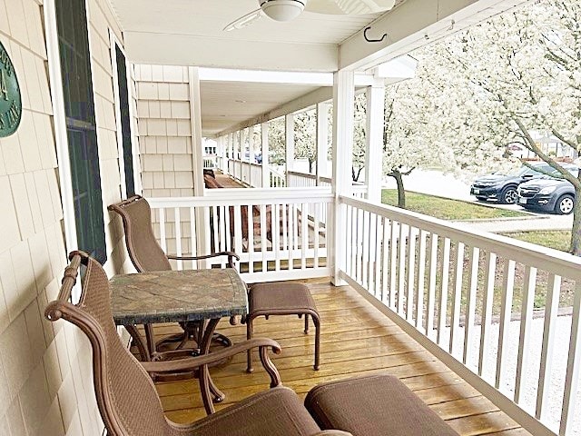 exterior space with a porch, a ceiling fan, and outdoor dining space