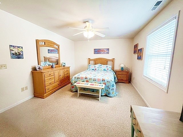 bedroom featuring carpet floors, visible vents, baseboards, and a ceiling fan