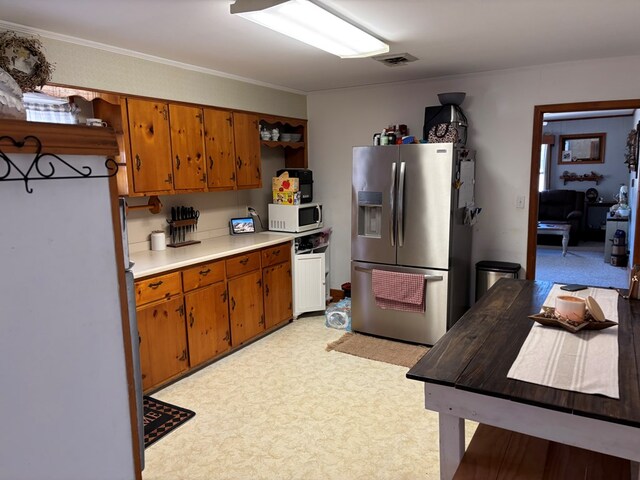 kitchen with crown molding, stainless steel fridge, and refrigerator