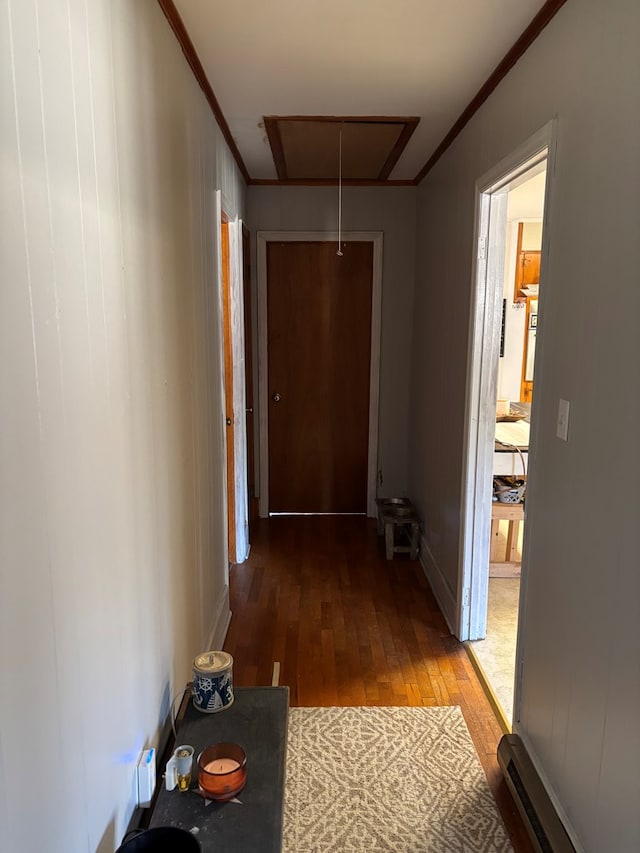 corridor featuring hardwood / wood-style flooring, a baseboard radiator, and crown molding
