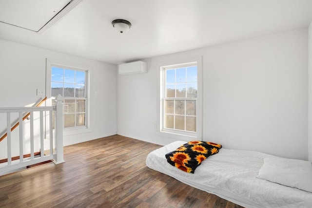 bedroom featuring multiple windows, a wall unit AC, and dark hardwood / wood-style floors