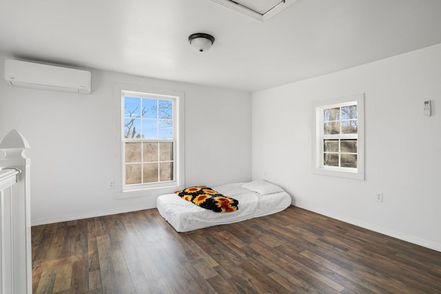 unfurnished bedroom featuring multiple windows, dark hardwood / wood-style floors, and a wall unit AC