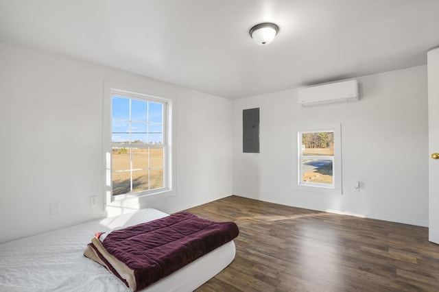 bedroom featuring multiple windows, a wall mounted air conditioner, electric panel, and dark hardwood / wood-style flooring