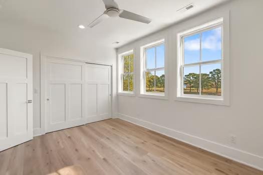 unfurnished bedroom with ceiling fan, light hardwood / wood-style floors, and a closet