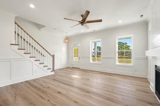 unfurnished living room featuring ceiling fan and light wood-type flooring