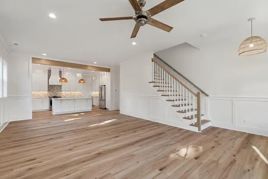 unfurnished living room featuring light hardwood / wood-style flooring and ceiling fan