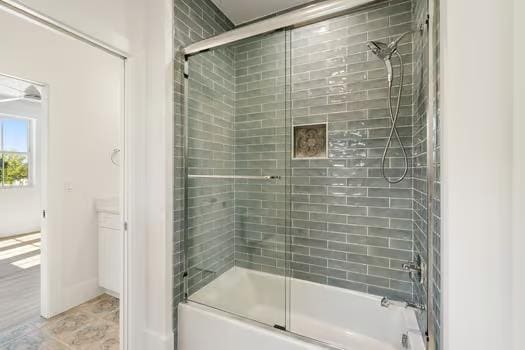 bathroom with bath / shower combo with glass door