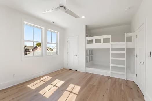 unfurnished bedroom with ceiling fan and light hardwood / wood-style floors