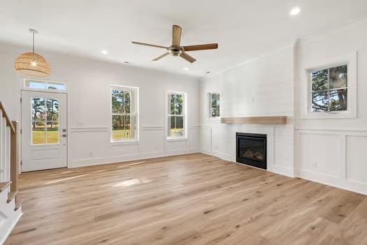 unfurnished living room with a fireplace, light hardwood / wood-style floors, and ceiling fan