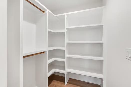 walk in closet with hardwood / wood-style floors