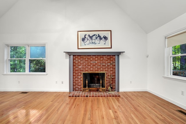 3315 Seaside Rd, Exmore, VA 23350 - unfurnished living room with wood finished floors, high vaulted ceiling, a brick fireplace, and baseboards