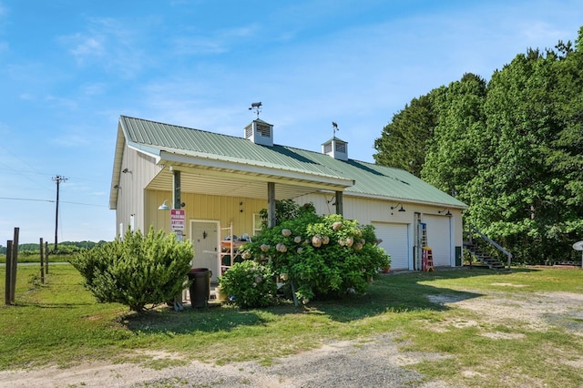 3315 Seaside Rd, Exmore, VA 23350 - view of front facade featuring a chimney, metal roof, a garage, a front yard, and driveway