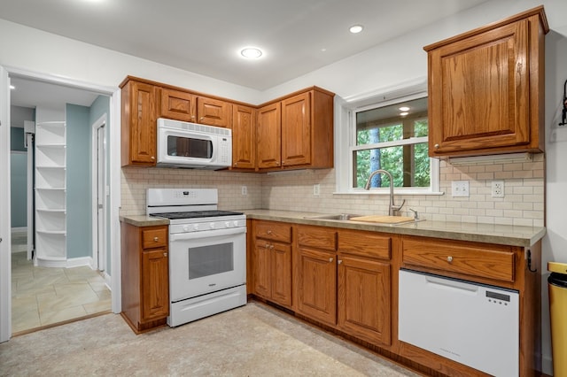 3315 Seaside Rd, Exmore, VA 23350 - kitchen with white appliances, a sink, brown cabinetry, backsplash, and baseboards