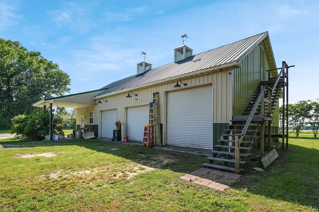 3315 Seaside Rd, Exmore, VA 23350 - view of property exterior featuring stairway, a lawn, metal roof, a detached garage, and board and batten siding