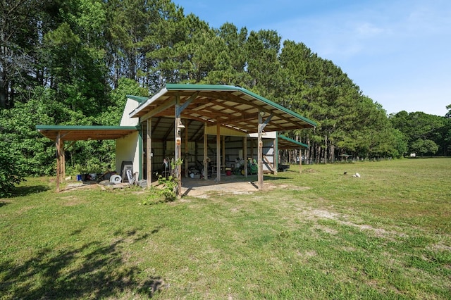 3315 Seaside Rd, Exmore, VA 23350 - view of grassy yard featuring a pole building, an outbuilding, and a forest view