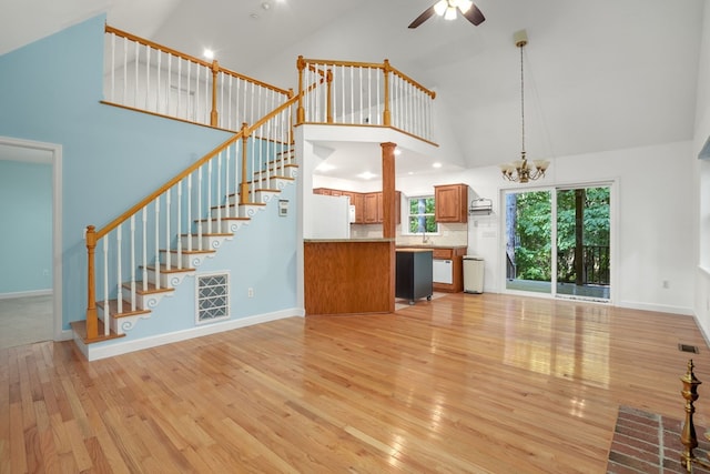 3315 Seaside Rd, Exmore, VA 23350 - unfurnished living room with high vaulted ceiling, light wood-type flooring, a ceiling fan, stairs, and a chandelier