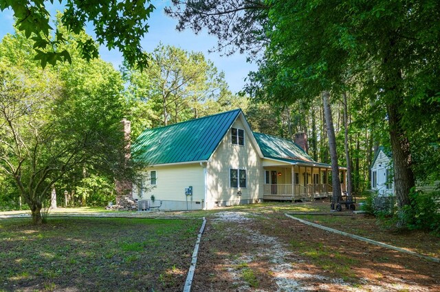 3315 Seaside Rd, Exmore, VA 23350 - view of side of property with a chimney, a porch, metal roof, and central AC