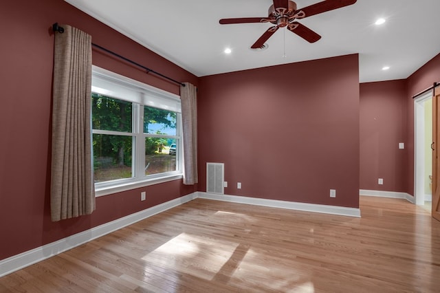 3315 Seaside Rd, Exmore, VA 23350 - empty room featuring a barn door, light wood-type flooring, ceiling fan, baseboards, and recessed lighting