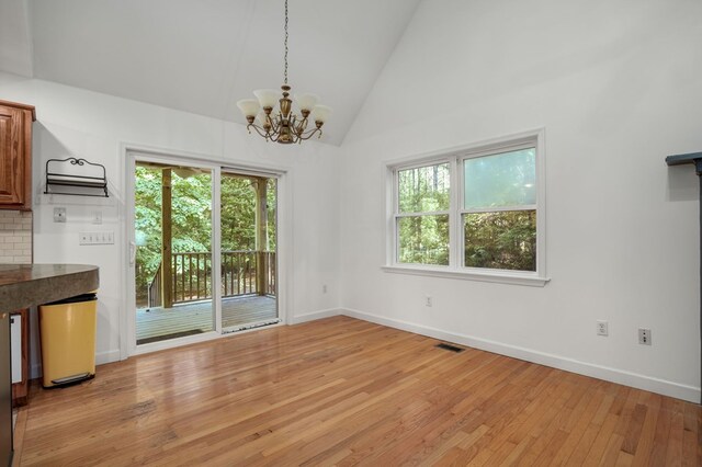 3315 Seaside Rd, Exmore, VA 23350 - unfurnished dining area with a chandelier, light wood-type flooring, baseboards, and high vaulted ceiling