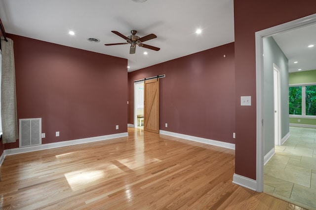 3315 Seaside Rd, Exmore, VA 23350 - unfurnished room featuring a barn door, a ceiling fan, baseboards, light wood-style flooring, and recessed lighting