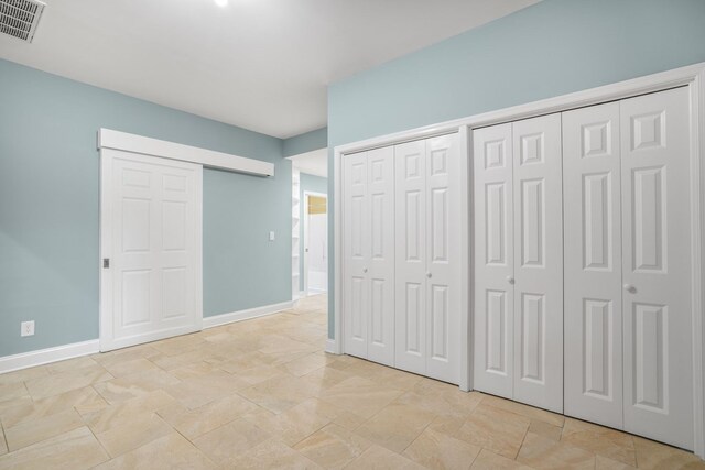 3315 Seaside Rd, Exmore, VA 23350 - unfurnished bedroom with two closets, baseboards, and light stone finish floors