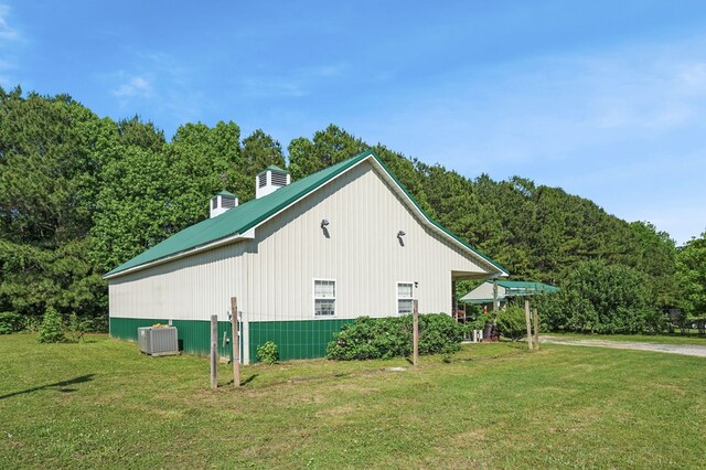 3315 Seaside Rd, Exmore, VA 23350 - view of property exterior featuring central AC unit, a yard, a chimney, and metal roof