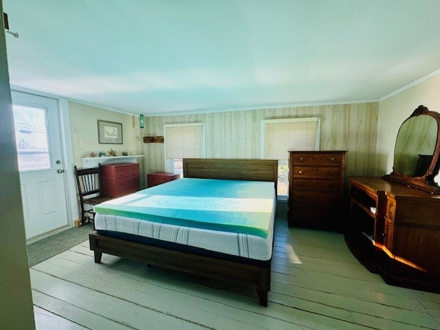 bedroom with light wood-type flooring and ornamental molding