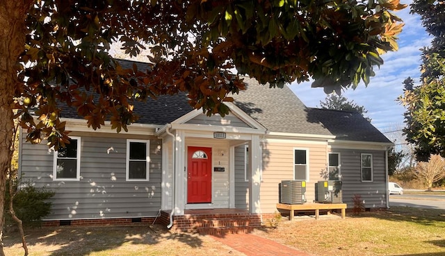 view of front of home featuring crawl space, a front yard, cooling unit, and roof with shingles