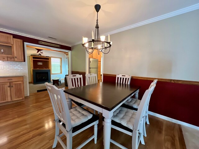 dining area featuring a chandelier, dark hardwood / wood-style floors, and crown molding