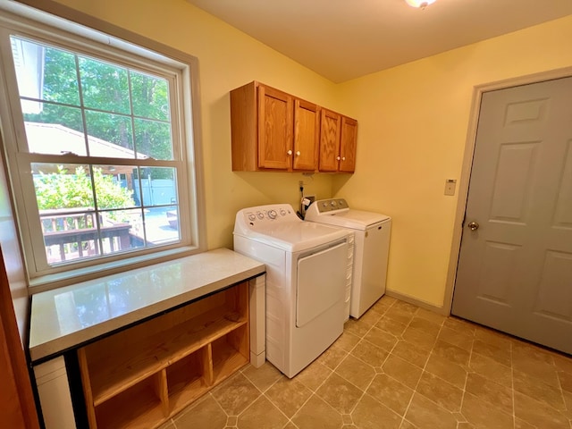 washroom with washer and clothes dryer and cabinets