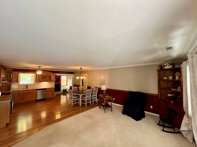 interior space with crown molding, sink, carpet floors, and ceiling fan with notable chandelier