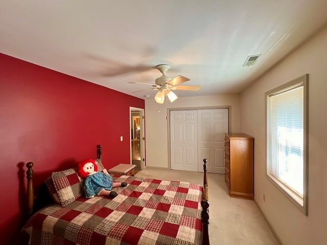 carpeted bedroom with ceiling fan and a closet