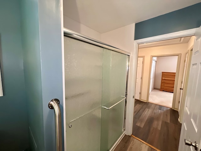 bathroom featuring wood-type flooring and a shower with shower door