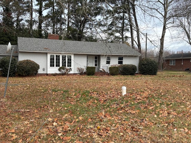 view of front of home with a front lawn and roof with shingles