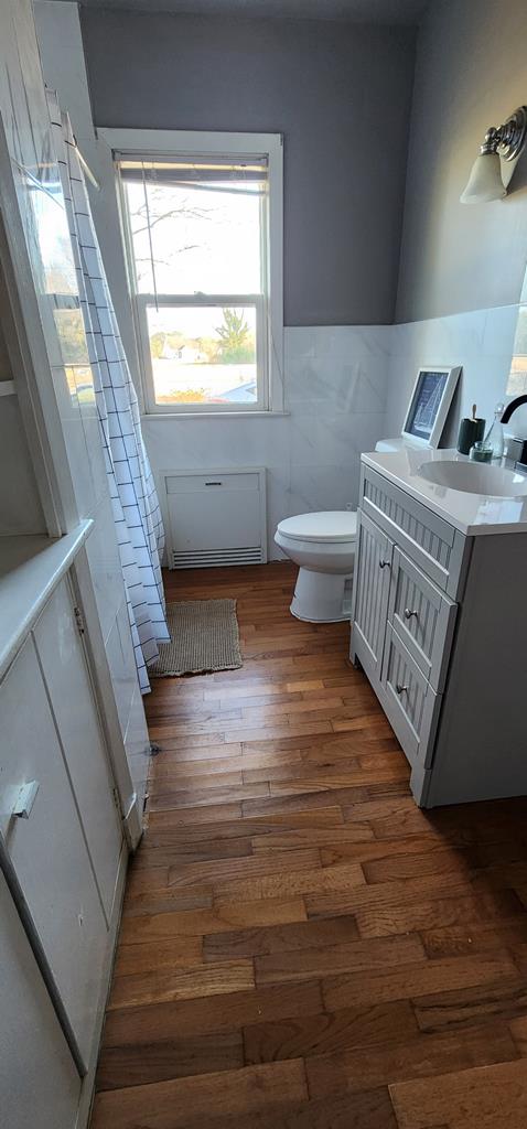 10117 Pine Ave, Nassawadox, VA 23413 - bathroom featuring a wainscoted wall, wood-type flooring, vanity, and toilet