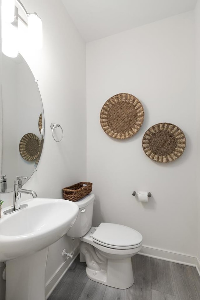 bathroom with toilet and hardwood / wood-style flooring